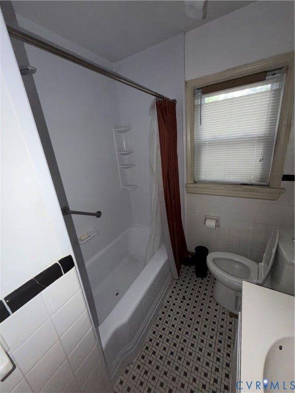3605 Dill Road, Henrico, VA 23222 Bathroom featuring a white tub, patterned floor tile, white wall tile with black accent, and a window with blinds