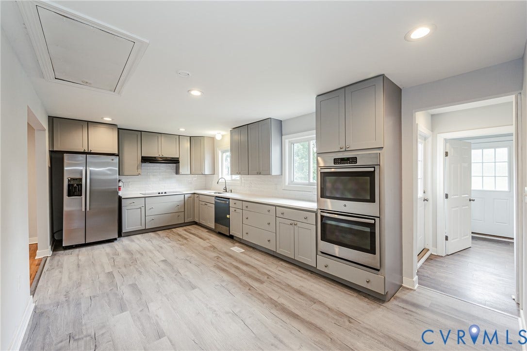 2015 Fordson Road, Richmond, VA 23229 Modern kitchen featuring grey shaker-style cabinetry, stainless steel appliances, white subway tile backsplash, and light wood-finish flooring
