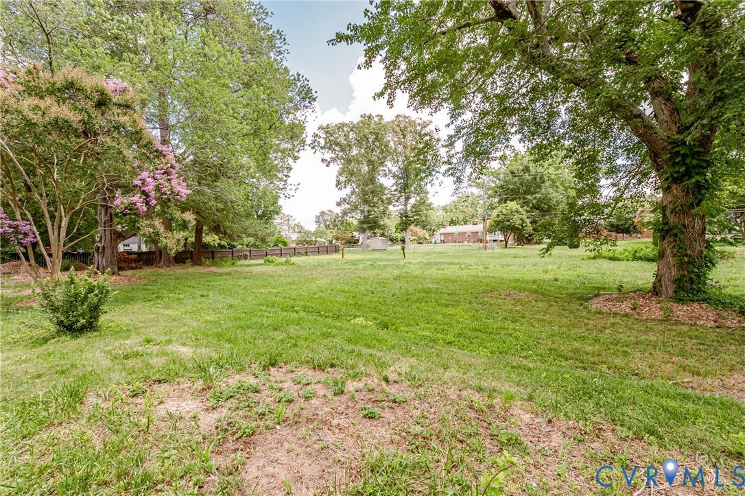 2015 Fordson Road, Richmond, VA 23229 Expansive green lawn with mature trees and a wooden fence defining the property line