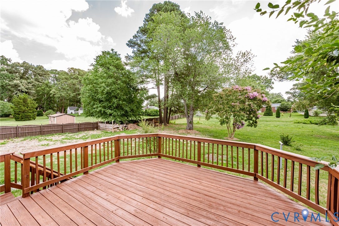 2015 Fordson Road, Richmond, VA 23229 Expansive wood deck with rich stain and full railing system, offering exterior access and surrounding green space with mature trees