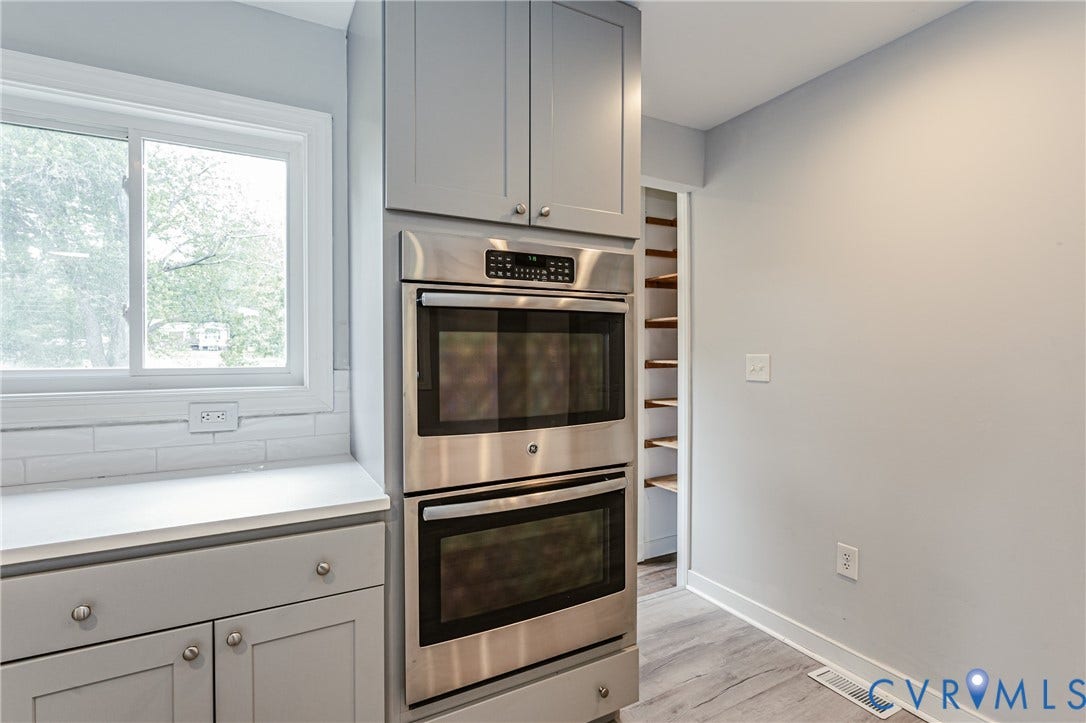 2015 Fordson Road, Richmond, VA 23229 Stainless steel double ovens integrated into gray cabinetry, complemented by a white countertop and coordinating subway tile backsplash