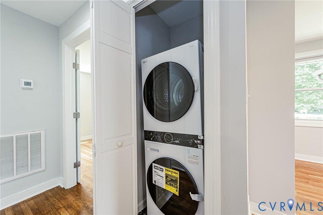 2015 Fordson Road, Richmond, VA 23229 Laundry closet with a stacked washer and dryer, wood-finish flooring, light grey wall paint, and white trim