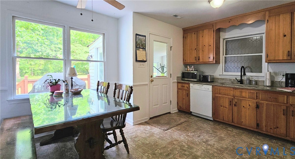 Kitchen featuring wood cabinetry, a granite-look countertop, and a black gooseneck faucet