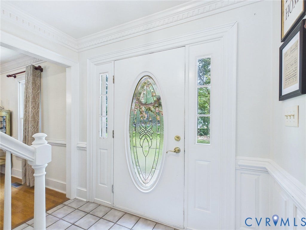 14301 Creek Stone Drive, Chesterfield, VA 23838 Entryway featuring a decorative oval-paneled door with sidelights, complemented by white wainscoting and crown molding