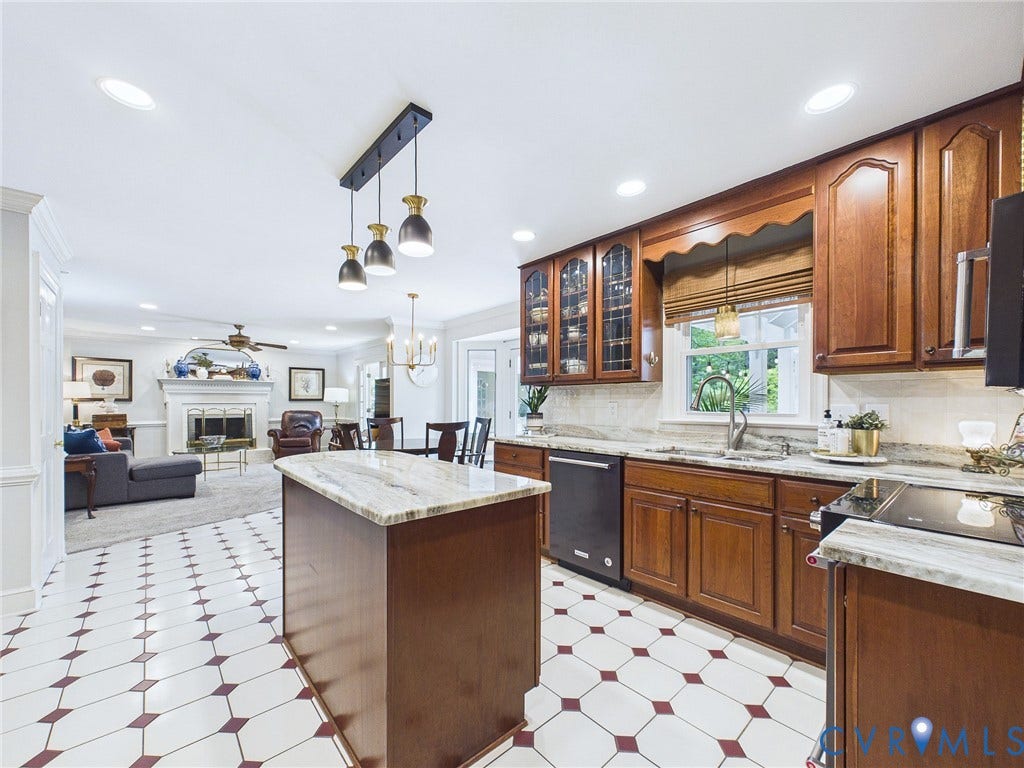 14301 Creek Stone Drive, Chesterfield, VA 23838 Kitchen featuring wood cabinetry, light-toned stone countertops, and a tile floor with geometric accents