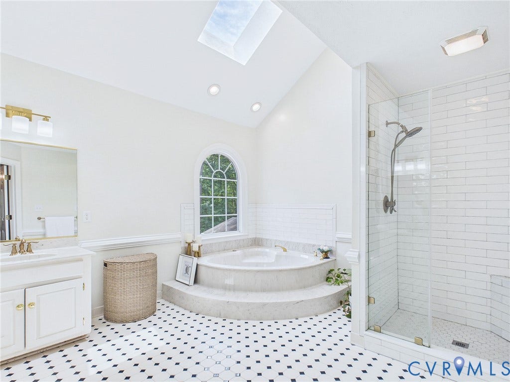14301 Creek Stone Drive, Chesterfield, VA 23838 Bathroom featuring a built-in jetted tub with tiled surround, a separate glass-enclosed shower, a double vanity with a marble-finish countertop, and black and white patterned floor tiling