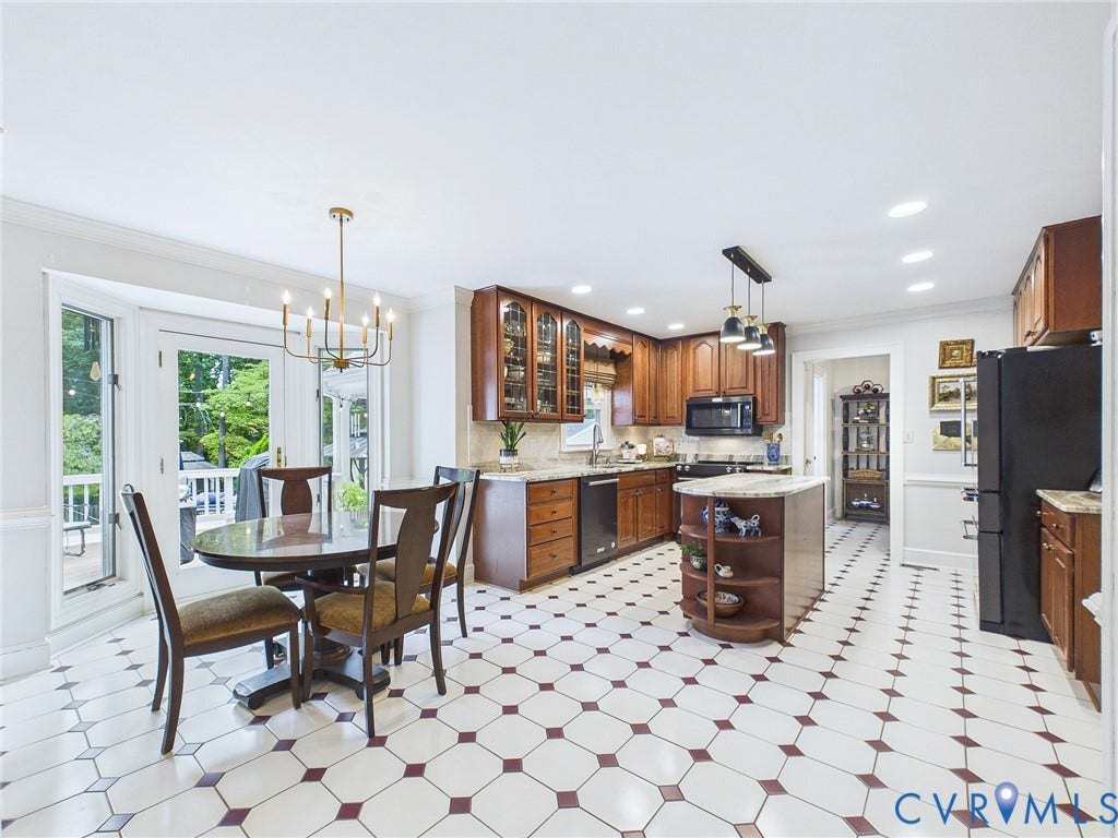 14301 Creek Stone Drive, Chesterfield, VA 23838 Eat-in kitchen featuring patterned tile flooring, wood cabinetry with glass accents, light granite countertops, and a central island with integrated shelving
