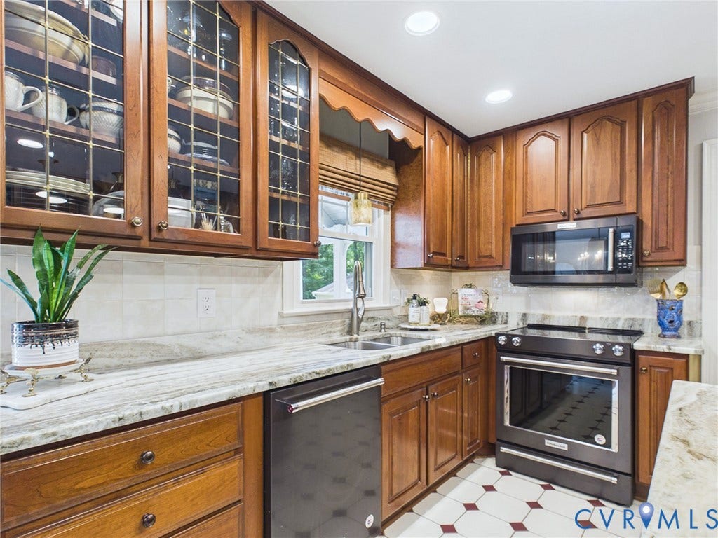 14301 Creek Stone Drive, Chesterfield, VA 23838 Kitchen featuring wood-finish cabinetry, patterned flooring, light-toned countertops, a stainless steel sink, and built-in appliances
