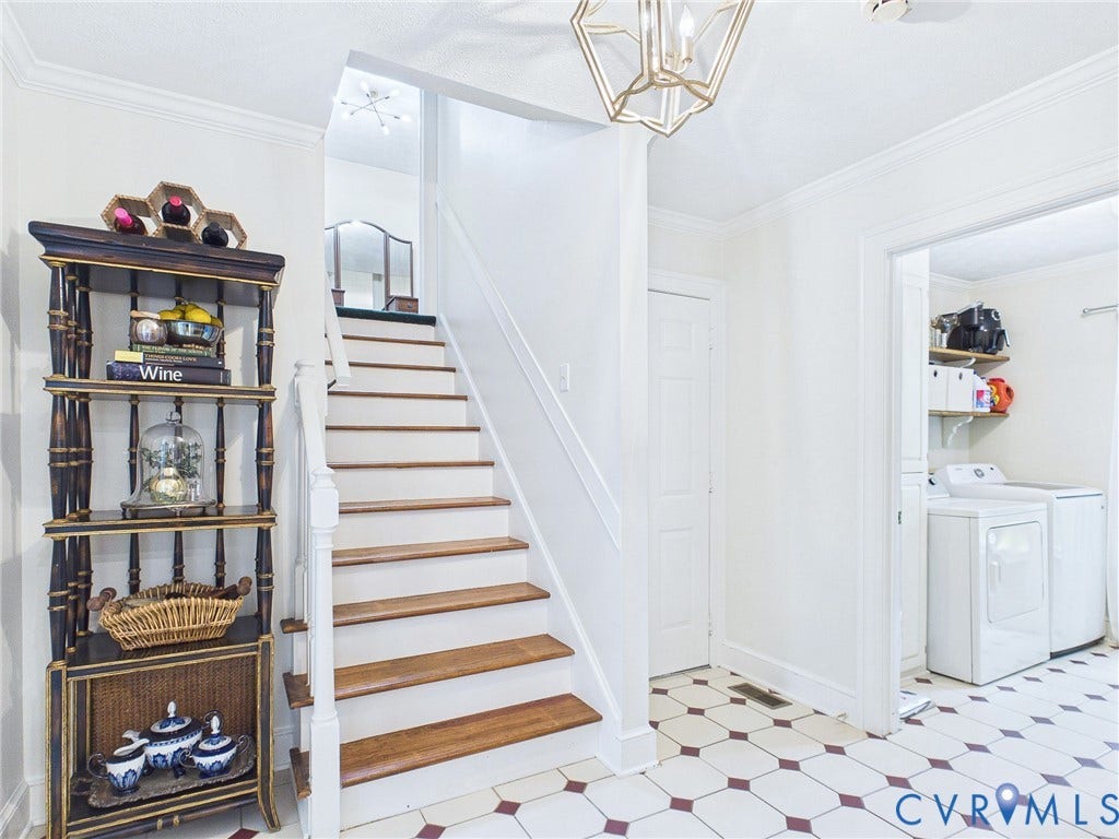 14301 Creek Stone Drive, Chesterfield, VA 23838 Foyer featuring a geometric pattern tile floor, wood tread staircase with white risers and railing, a built-in shelving unit, and an overhead decorative light fixture