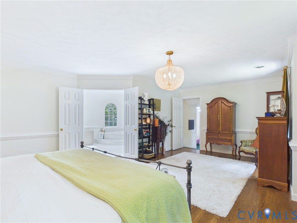 14301 Creek Stone Drive, Chesterfield, VA 23838 Spacious room featuring hardwood flooring, crown molding, and a prominent chandelier