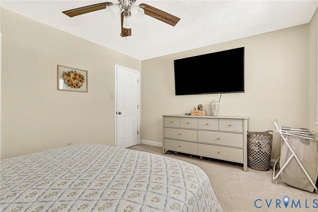 348 Forest Lane, Timberland Estates, King William, VA 23086 Carpeted interior space featuring a ceiling fan with integrated lighting, neutral wall tones, and a white paneled door