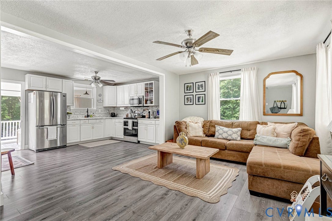 348 Forest Lane, Timberland Estates, King William, VA 23086 Open-concept living space featuring wood-finish flooring, white cabinetry, stainless steel appliances, and a ceiling fan