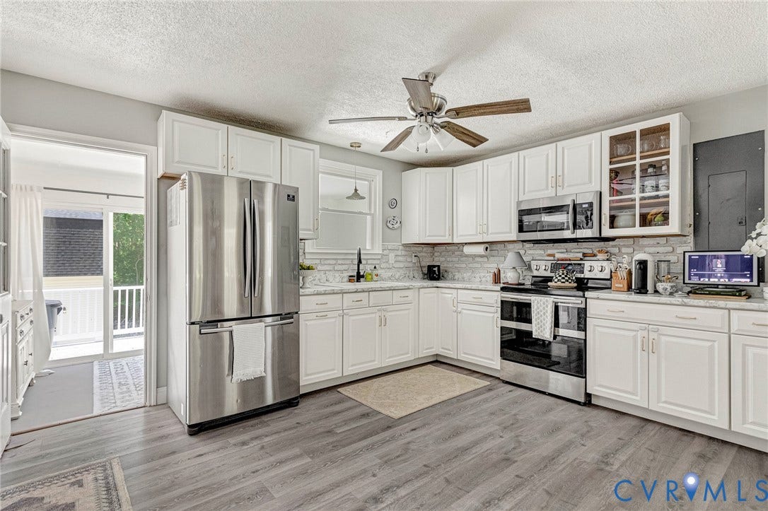 348 Forest Lane, Timberland Estates, King William, VA 23086 Kitchen featuring white cabinetry, stainless steel appliances, wood-finish flooring, a white brick-style backsplash, and light-toned countertops