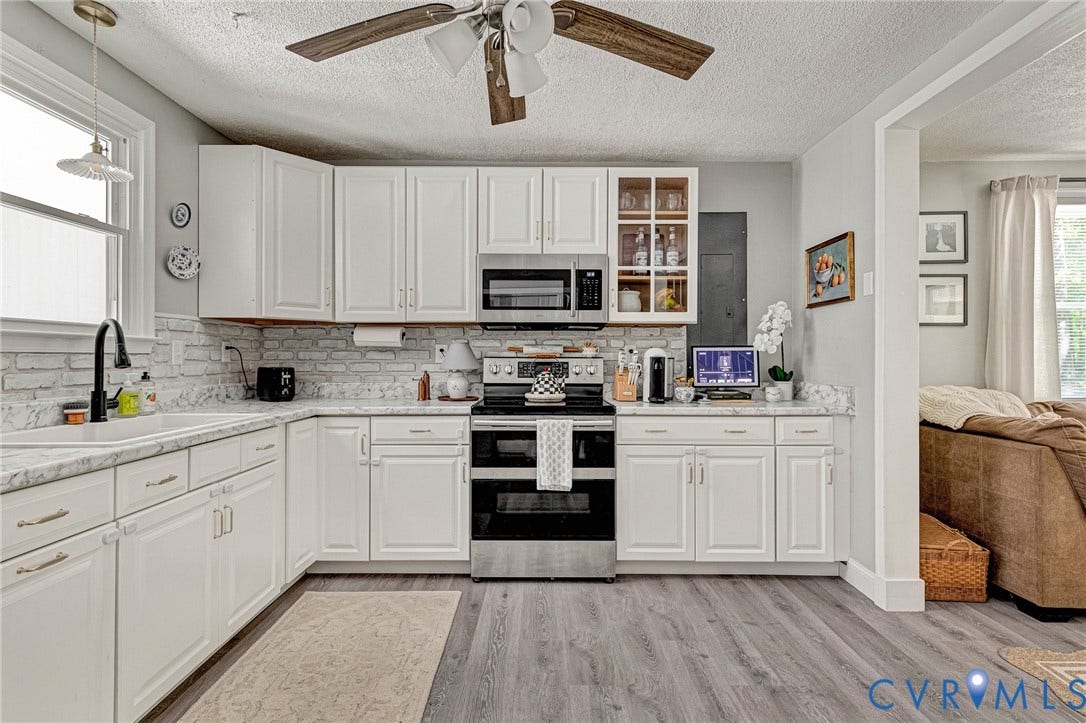 348 Forest Lane, Timberland Estates, King William, VA 23086 Kitchen featuring white cabinetry, light-toned countertops, a white brick-finish backsplash, stainless steel appliances, and wood-finish flooring
