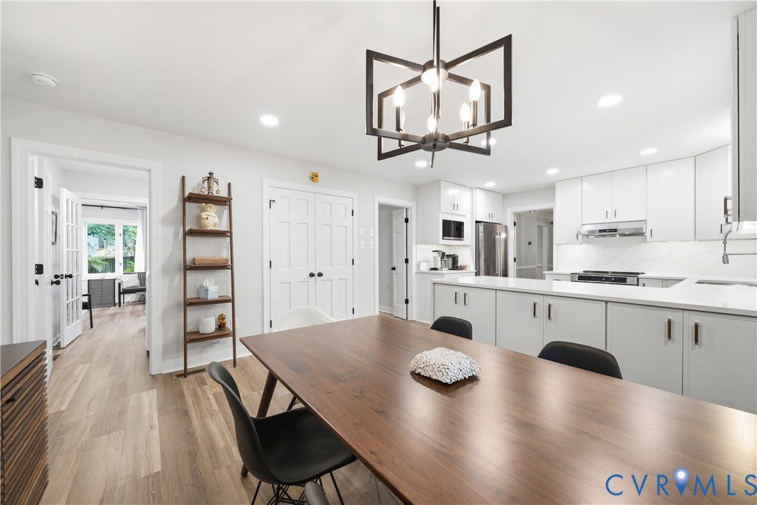 Open-concept kitchen featuring recessed lighting, a modern chandelier, white flat-panel cabinetry, stainless steel appliances, and wood-finish flooring