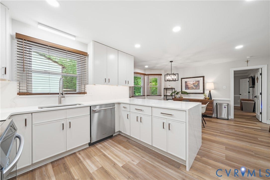 Contemporary kitchen featuring white cabinetry, integrated stainless steel appliances, and wood-finish flooring