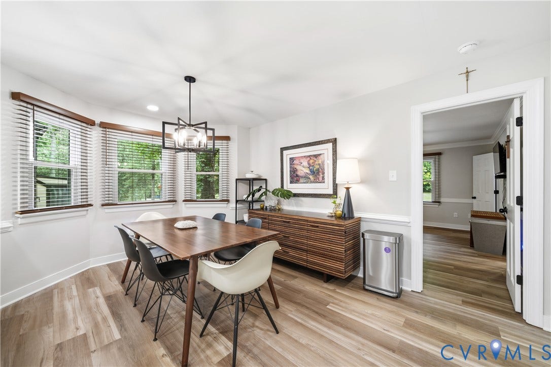 Dining area featuring wood-finish flooring, white baseboards, and a chair rail molding