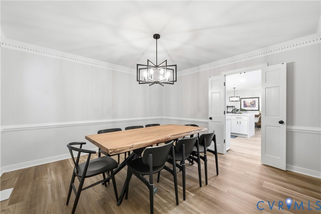 Dining room featuring wood-finish flooring, a modern chandelier, and decorative crown molding