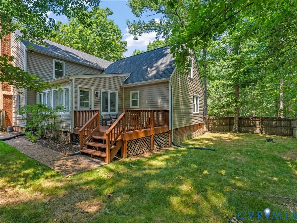 Exterior featuring light-toned horizontal siding, a multi-level wood deck, a brick chimney, and a gravel pathway
