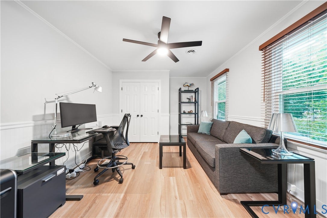 Light wood-finish flooring complements white walls with wainscoting