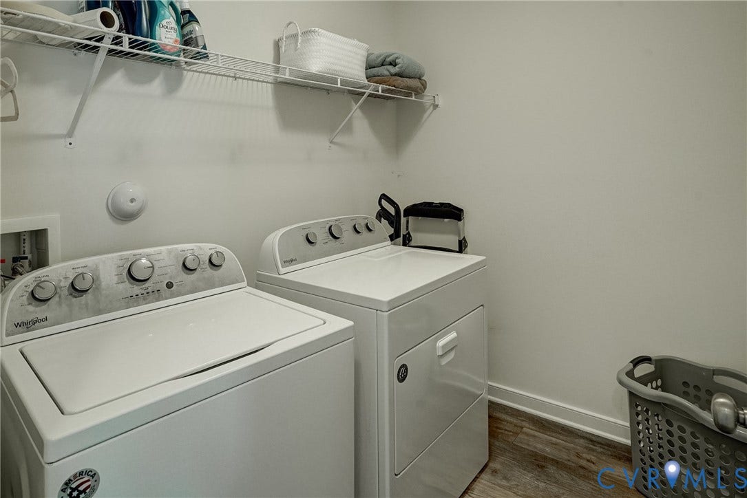 18024 Twin Falls Lane, Aston Oaks, Moseley, VA 23120 Dedicated laundry area featuring a top-load washer and front-load dryer, wood-finish flooring, white baseboards, and overhead wire shelving