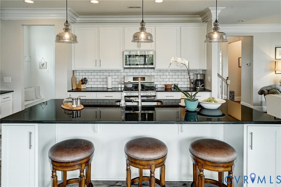 18024 Twin Falls Lane, Aston Oaks, Moseley, VA 23120 Gourmet kitchen featuring a large island with a dark countertop, white shaker cabinetry, stainless steel appliances, a subway tile backsplash, and decorative pendant lighting