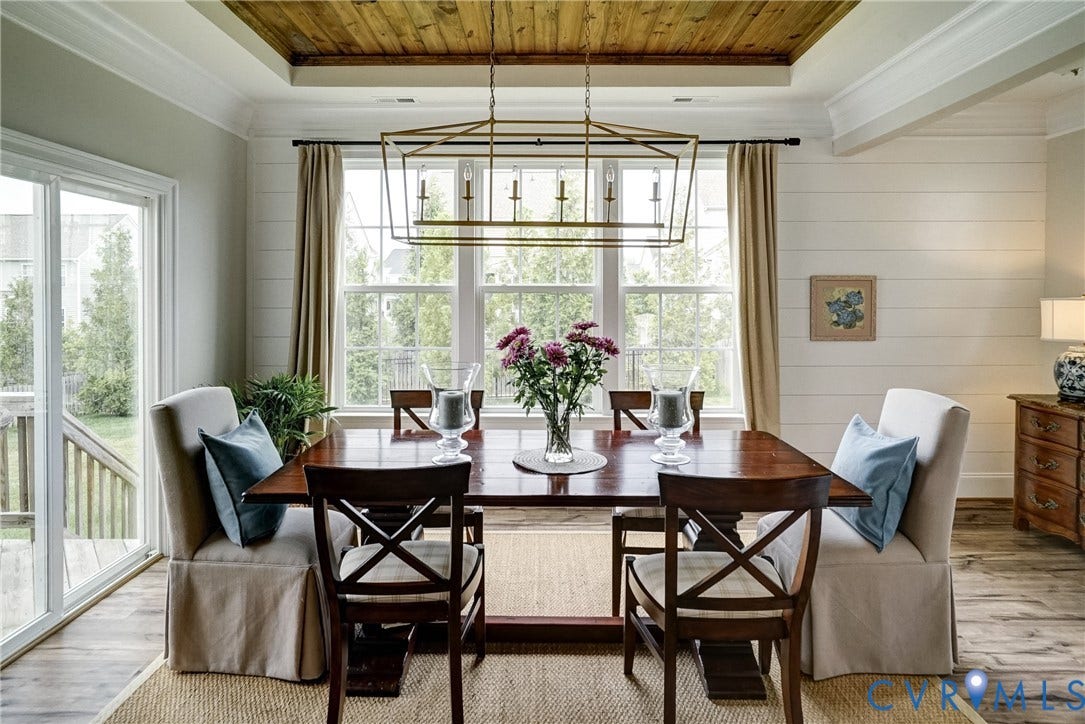 18024 Twin Falls Lane, Aston Oaks, Moseley, VA 23120 Dining area featuring a tray ceiling with wood-finish paneling, shiplap accent wall, large window, and sliding glass door to exterior