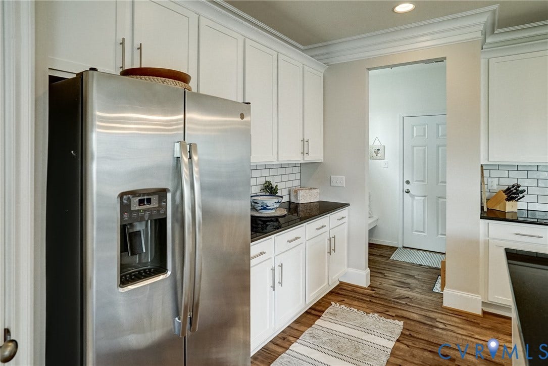 18024 Twin Falls Lane, Aston Oaks, Moseley, VA 23120 Kitchen featuring stainless steel refrigerator with ice and water dispenser, white shaker cabinetry, dark countertops, white subway tile backsplash, and wood-finish flooring