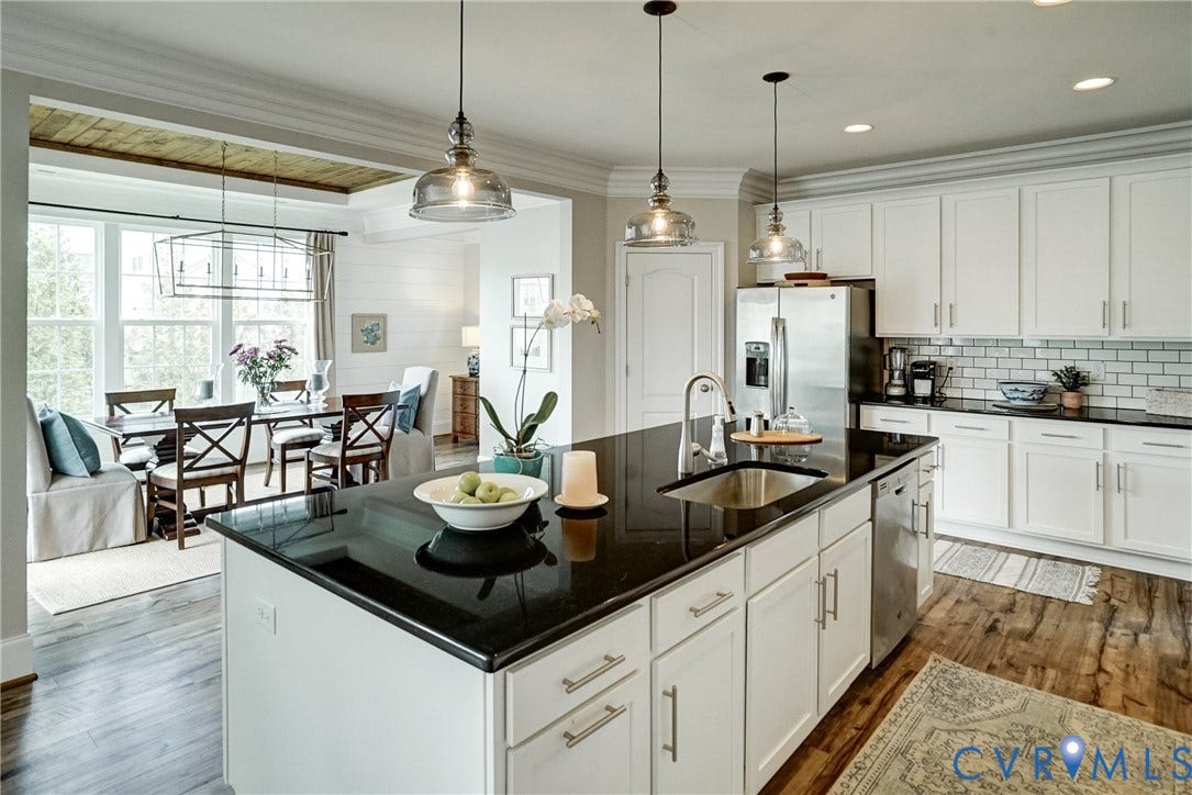 18024 Twin Falls Lane, Aston Oaks, Moseley, VA 23120 Kitchen featuring a large island with a stainless steel sink, white cabinetry, dark countertops, and subway tile backsplash