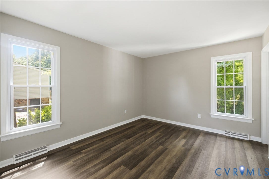 3224 Wyntrebrooke Drive, North Chesterfield, VA 23235 Light-filled interior space featuring two large windows with white trim, wood-finish flooring, and light-toned wall paint