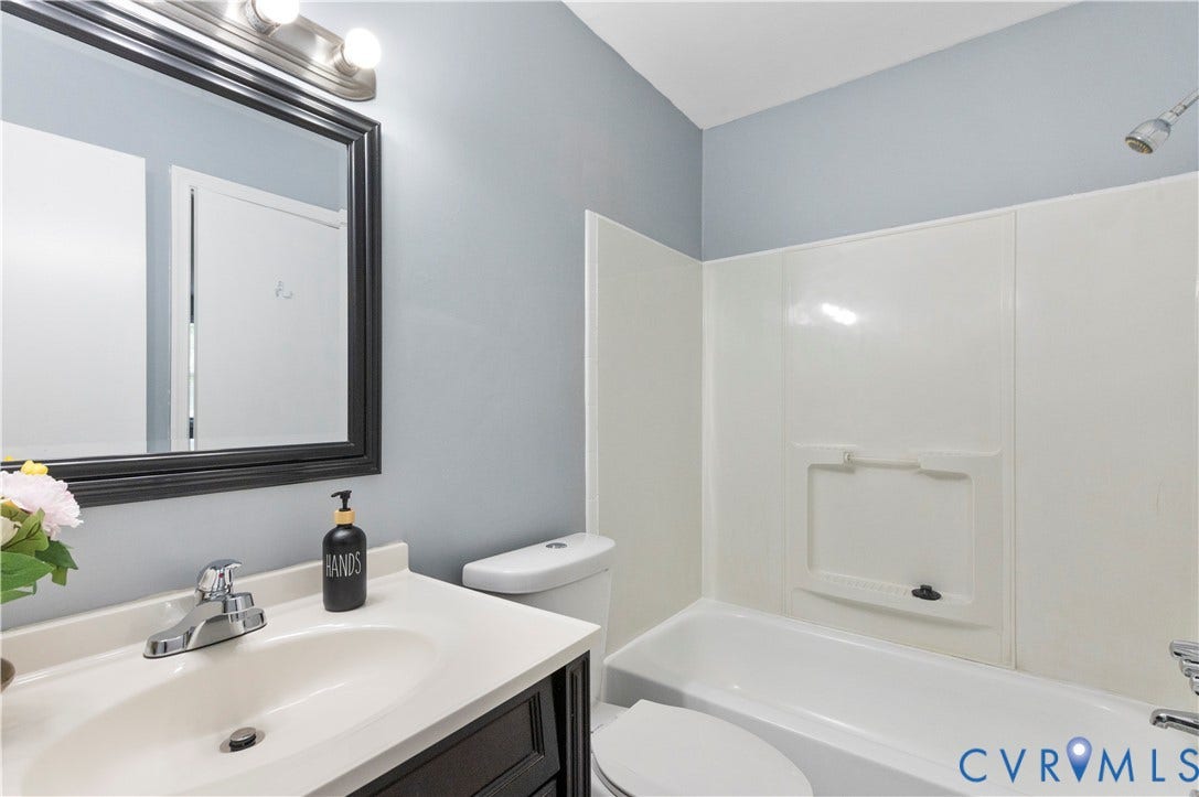 908 Winterstick Place, Highland Springs, VA 23223 Bathroom featuring a white vanity with a single basin sink, a framed mirror, and a full bathtub with a white surround