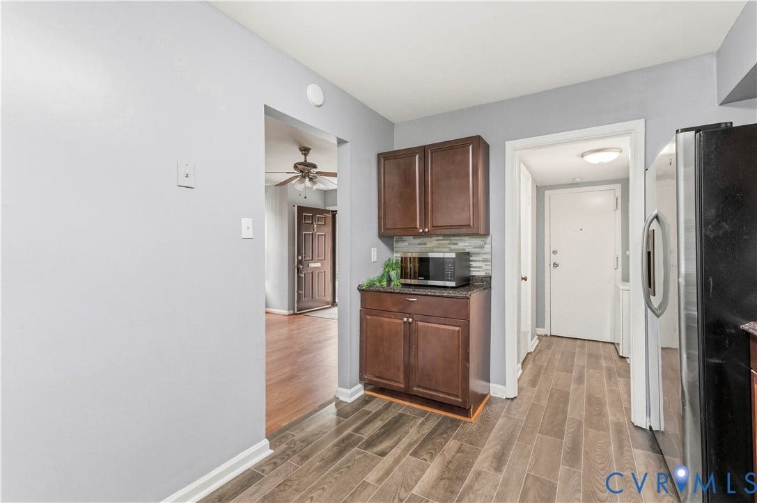 908 Winterstick Place, Highland Springs, VA 23223 Wood-finish flooring throughout, complemented by a built-in cabinetry unit with a dark countertop and a tiled backsplash