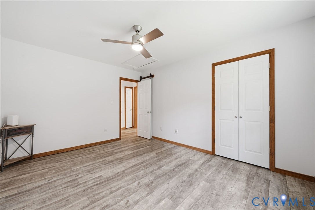 2231 Red Lane Road, Powhatan, VA 23139 Bedroom #3 - Spacious third bedroom showcasing a ceiling fan w/brushed metal finish, & dual closets w/white panel doors & wood-finish trim. Attic access.