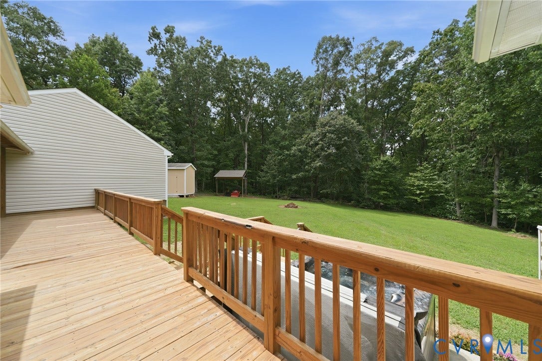 2231 Red Lane Road, Powhatan, VA 23139 Expansive wooden deck with natural wood railing overlooking a lush green lawn