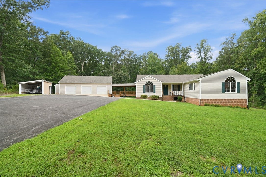 2231 Red Lane Road, Powhatan, VA 23139 Charming single-level style residence featuring a spacious asphalt driveway, three-car garage w/additional storage structure, shed, manicured lawn w/mature tree landscaping, & a brick foundation.