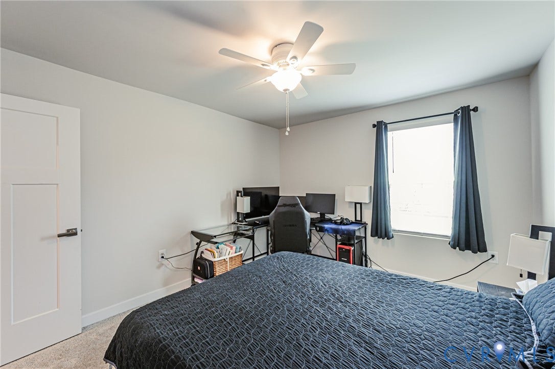 7627 E Danube Loop, New Kent, VA 23124 Bedroom with carpeting and a window featuring a ceiling fan with integrated lighting