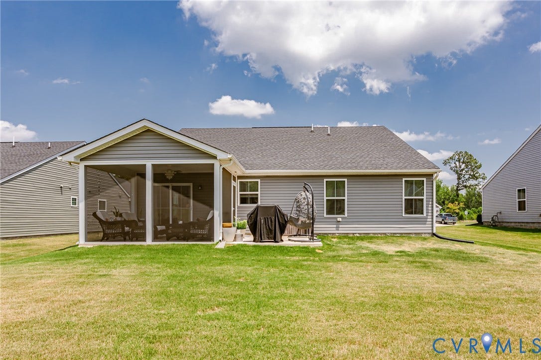 7627 E Danube Loop, New Kent, VA 23124 Expansive grassy yard area featuring a screened porch, sliding glass door access, and a durable shingle roof