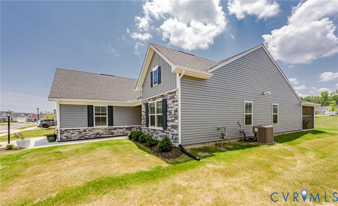 7627 E Danube Loop, New Kent, VA 23124 Exterior showcasing gray siding, dark shutters, and stone veneer accents