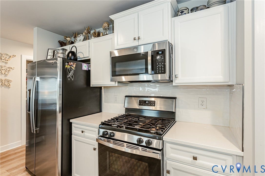 7627 E Danube Loop, New Kent, VA 23124 Kitchen featuring stainless steel appliances including a side-by-side refrigerator, gas range, and over-the-range microwave