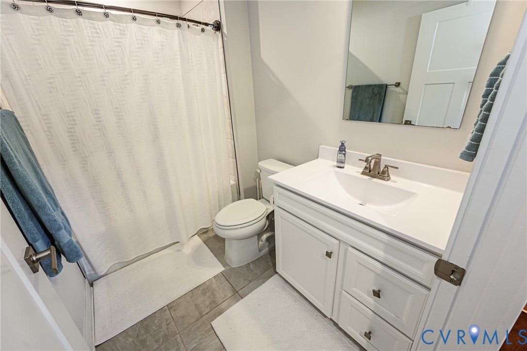 7627 E Danube Loop, New Kent, VA 23124 Bathroom featuring a white vanity with an integrated sink, brushed nickel faucet, and a wall-mounted mirror