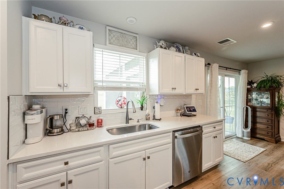 7627 E Danube Loop, New Kent, VA 23124 Kitchen featuring white shaker cabinetry, white subway tile backsplash, and light-toned countertops