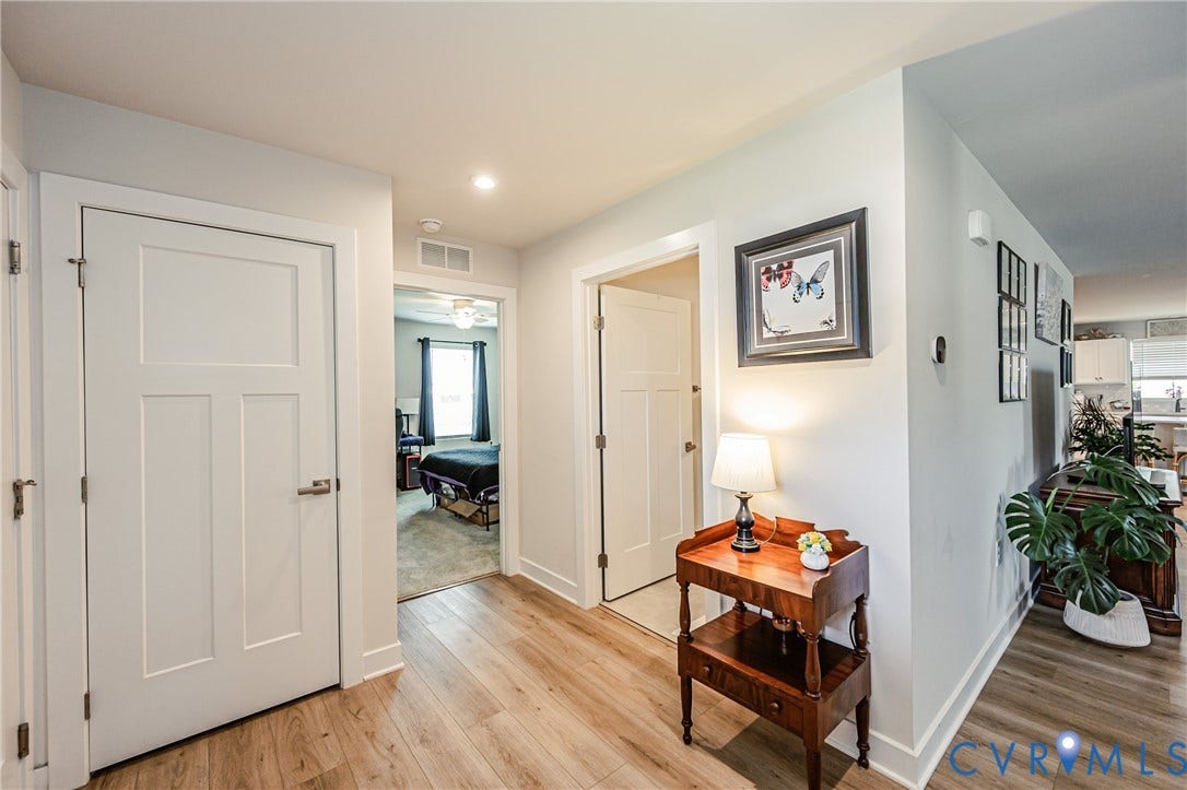 7627 E Danube Loop, New Kent, VA 23124 Hallway featuring wood-finish flooring, white trim, recessed lighting, and panel interior doors