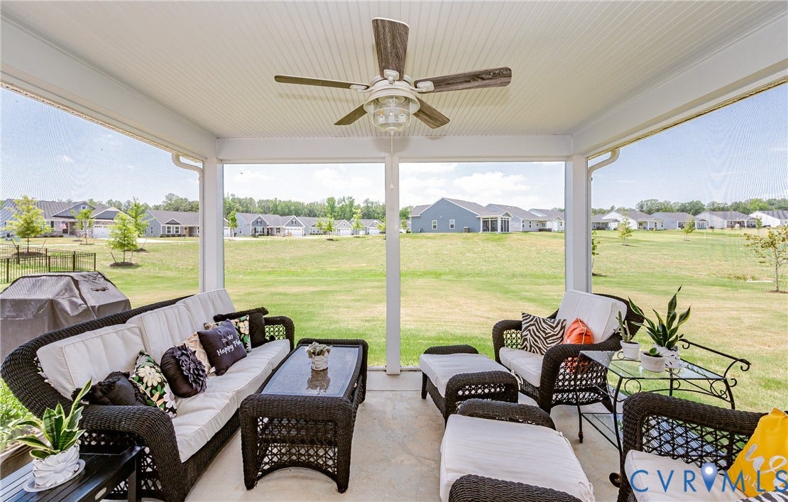 7627 E Danube Loop, New Kent, VA 23124 Screened porch featuring a wood-finish ceiling fan, concrete flooring, and views of the surrounding green space