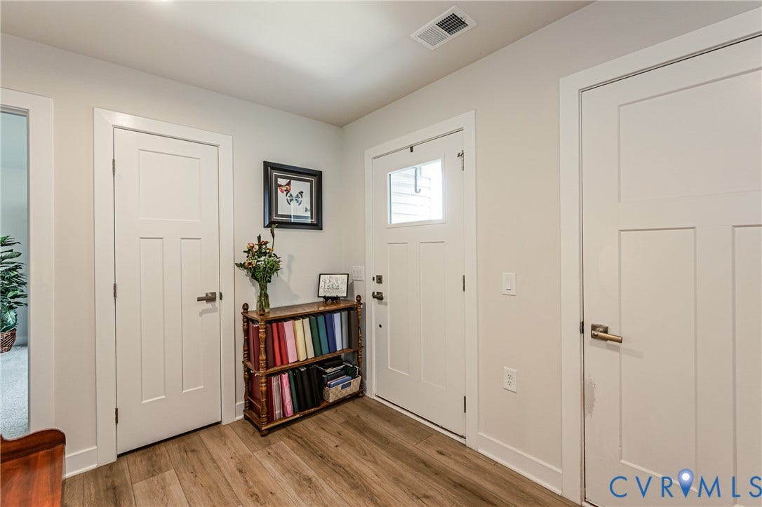 7627 E Danube Loop, New Kent, VA 23124 Entryway featuring wood-finish flooring, white paneled doors, and a front door with an integrated window