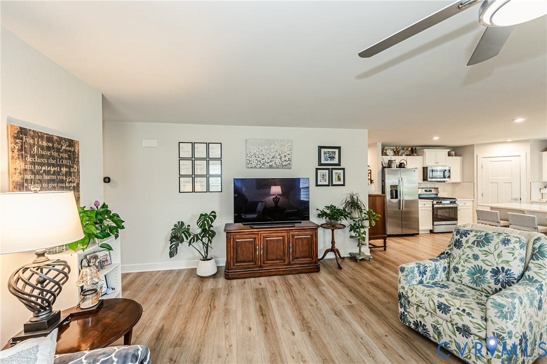 7627 E Danube Loop, New Kent, VA 23124 Open-concept living area featuring wood-finish flooring, a ceiling fan, and light-toned walls