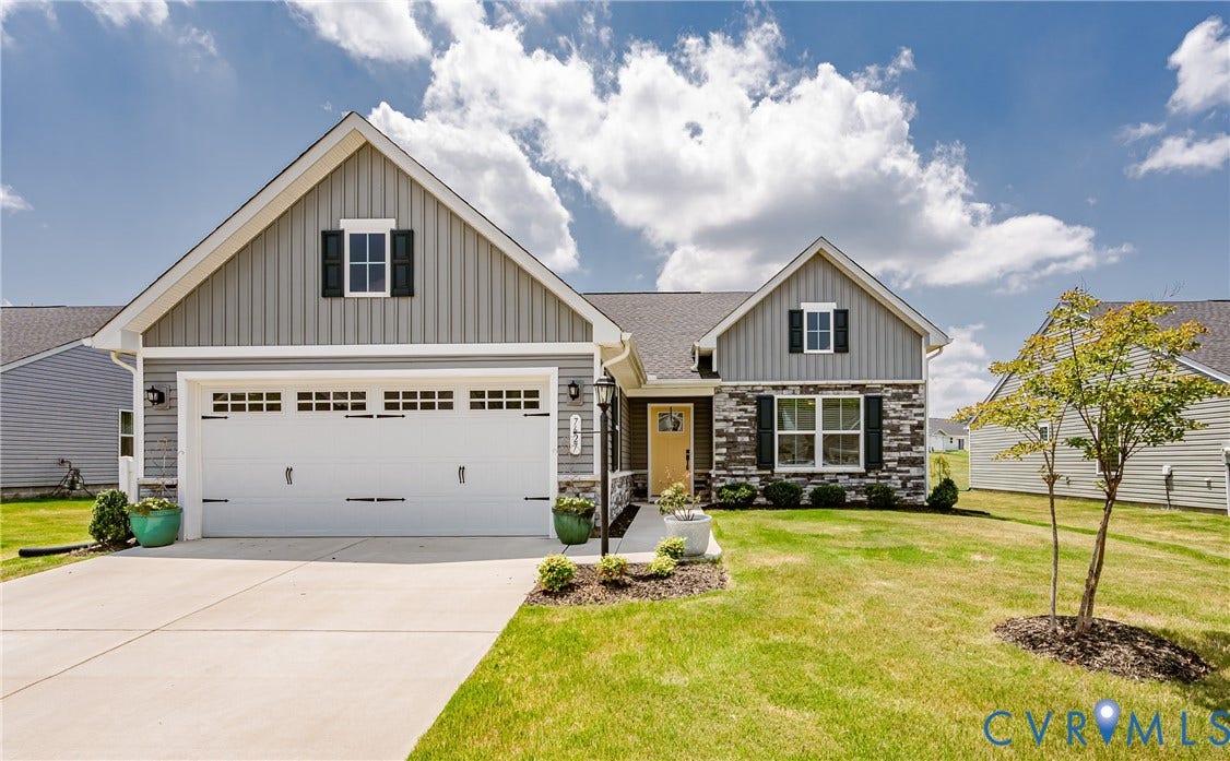 7627 E Danube Loop, New Kent, VA 23124 Modern ranch-style residence featuring a two-car garage, stone and siding facade, covered entry, and a front yard with established landscaping