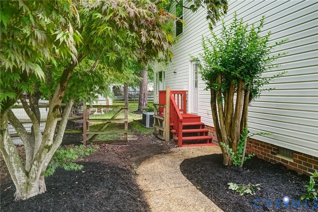 9724 Kingscroft Drive, Kingston, Glen Allen, VA 23060 Side exterior entrance featuring red-painted stairs with handrails, white siding, and a red brick foundation