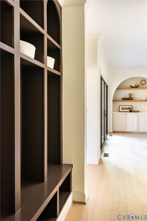 4507 Leonard Parkway, Richmond, VA 23221 Built-in dark wood shelving and bench seating, light wood-finish flooring, white baseboards, crown molding, and recessed wall niche with built-in cabinetry