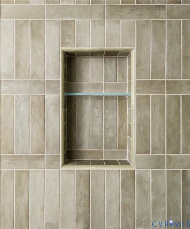 4507 Leonard Parkway, Richmond, VA 23221 Recessed tiled shower niche featuring a glass shelf, vertical tile pattern, and contrasting horizontal tile accents