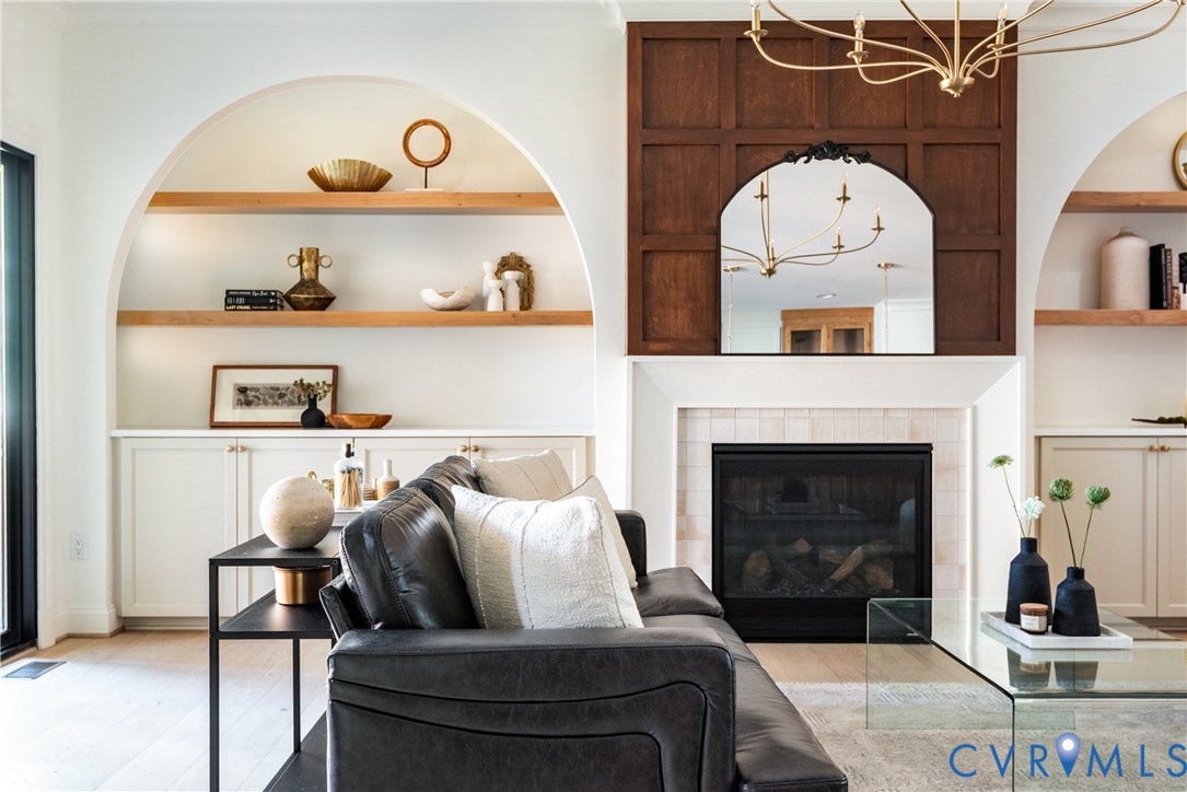 4507 Leonard Parkway, Richmond, VA 23221 Living area featuring a fireplace with a tiled surround, paneled wood accent wall, and arched built-in shelving